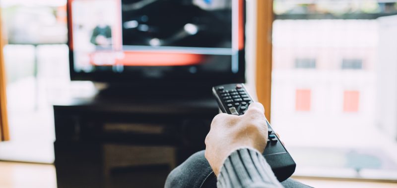 Close up man hand at home holding remote control